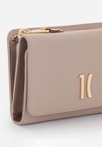 Portafoglio in pelle color talpa con rifiniture in metallo color oro. Caratterizzato da una chiusura con cerniera e un design elegante con logo in rilievo sulla parte anteriore.