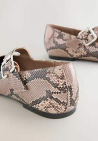Flat shoes with a pink and brown snake print pattern, featuring a silver buckle accent. Made of smooth synthetic material, low-profile sole.