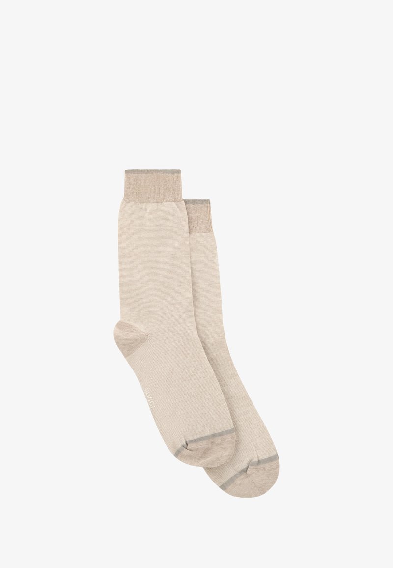 Paire de chaussettes beige montant avec des bordures, talons et orteils beige un peu plus foncés sur fond blanc.