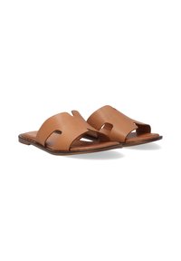 Brown leather slide sandals featuring wide straps with cut-out designs, a flat sole, and minimal detailing. Smooth texture with a matte finish.