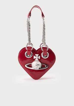 Bolso rojo en forma de corazón con emblema plateado de orbe y cruz y asas dobles de cadena plateada sobre fondo blanco.