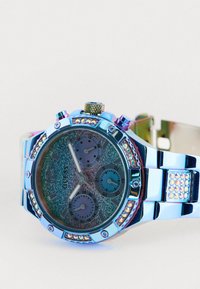 Reloj metálico plateado con acentos multicolores, una esfera brillante, tres subesferas y adornos de strass alrededor del bisel.
