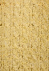 Maglione a trecce in morbido filato giallo, caratterizzato da un motivo testurizzato di cavi intrecciati, con un aspetto accogliente e leggermente peloso.