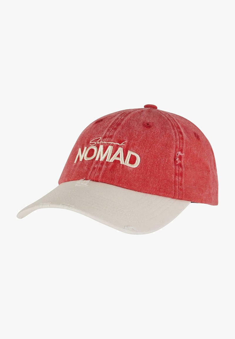 Rød bomullslue med en buet beige brem, med slitte detaljer og brodert "Nomad"-tekst i hvitt på forsiden.