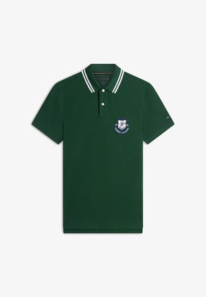 Donkergroene polo met witte dubbele strepen op de kraag, twee knopen en een blauw-wit Tommy Hilfiger-wapen op de borst.