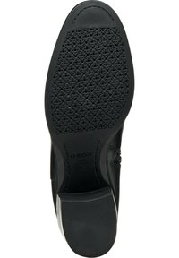 Semelle de chaussure noire avec une surface texturée, comportant de petites perforations et un talon robuste. Logo imprimé sur le côté. Bords lisses.