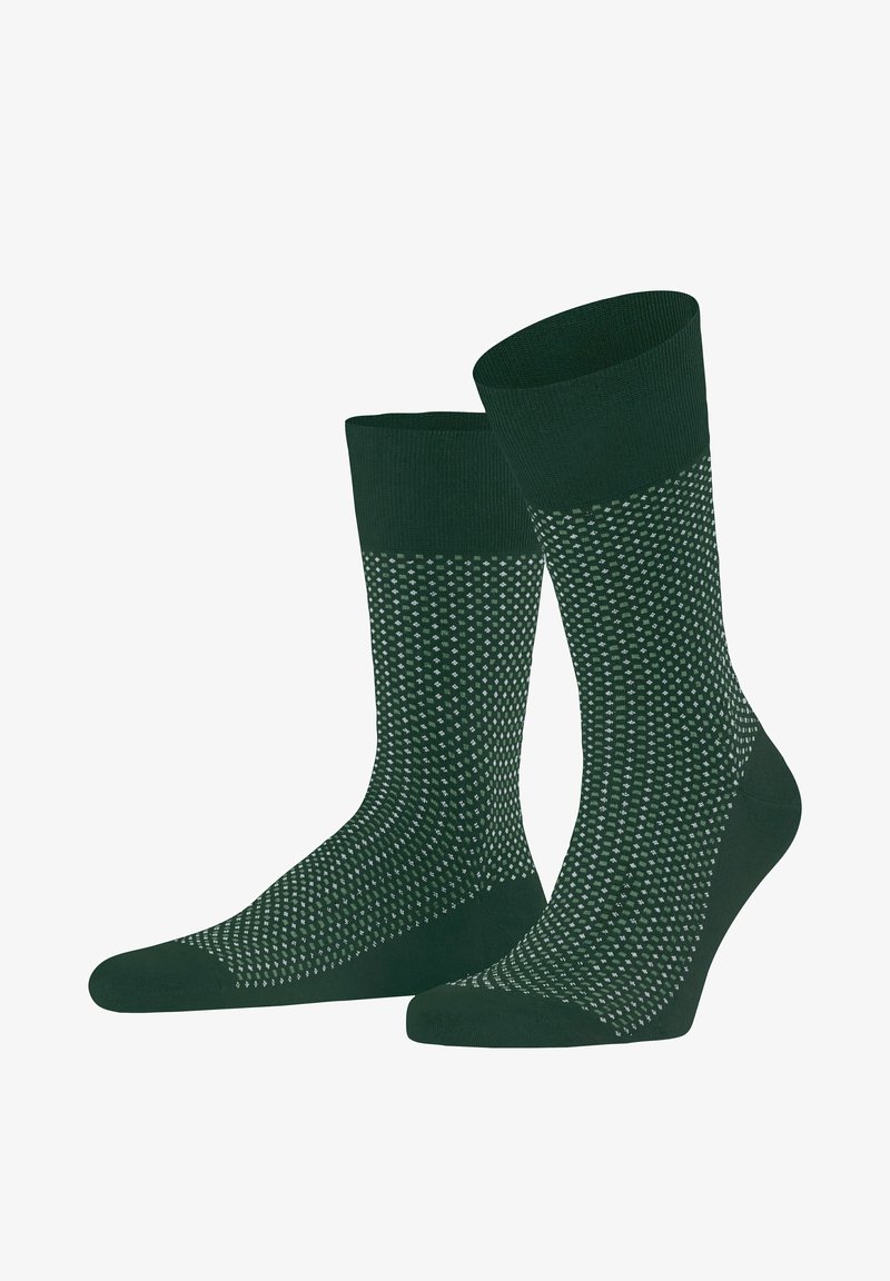 Grüne Socken mit einem kontrastierenden strukturierten Design, das kleine weiße Punkte aufweist. Hergestellt aus einem weichen, dehnbaren Stoff mit einem gerippten Oberrand.