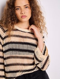 Beiger Strickpullover mit schwarzen horizontalen Streifen. Verfügt über ein offenes Maschenmuster, lange Ärmel und gerippte Bündchen. Auffällige Textur und Muster.