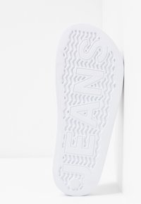 Semelle de chaussure en caoutchouc blanc avec motif en zigzag texturé et lettrage embossé "JEANS". Conçue pour l'adhérence et la traction.