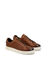 Brown leather sneakers with a smooth finish, rounded toe, white rubber sole, and subtle stitching detail. Laces through 5 eyelets.