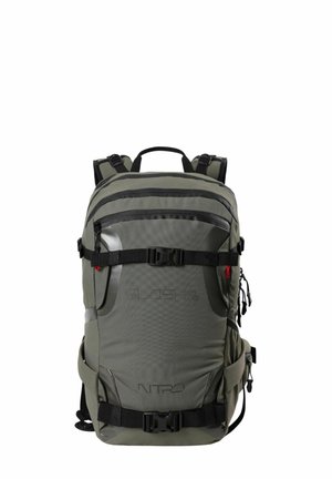 Olive green backpack with multiple zippered pockets, adjustable straps, black hardware, and a textured fabric with logo detailing.