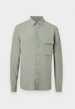 Chemise vert clair à manches longues avec boutons, col pointu et grande poche à rabat sur la poitrine gauche.