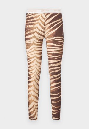 Rudos ir smėlio spalvos dryžuotos tamprės su tigro raštu, baltu juosmeniu, ant kurio yra šviesiai oranžine spalva pažymėtas užrašas „just cavalli“.