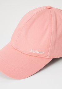 Rózsaszín baseball sapka pamut keverék anyagból. Ívelt karimával és varrott díszítéssel rendelkezik, a "Barbour" felirat fehér hímzéssel van ellátva.