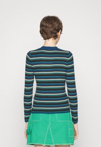 Pull à manches longues côtelé avec des rayures horizontales en bleu, vert, brun et beige. Encolure ras du cou, silhouette ajustée, avec une finition texturée.