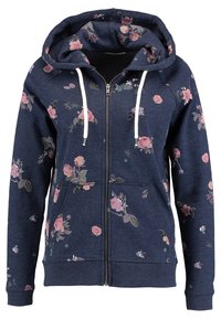 Sweat à capuche zippé bleu marine avec motif floral rose, poches avant, cordons blancs et capuche attachée.