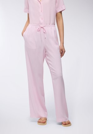 Jumpsuit a righe di un delicato rosa, con maniche corte, frontale con bottoni, vita elasticizzata e lacci. Tessuto morbido e liscio.