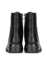Bottines noires avec une tige en cuir texturé, des zips sur les côtés et des semelles en caoutchouc robustes avec des crampons prononcés.