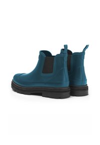 Bottes Chelsea en turquoise imperméables avec des panneaux latéraux élastiques noirs et une semelle en caoutchouc texturée, dotées de tirettes pour un enfilage facile.