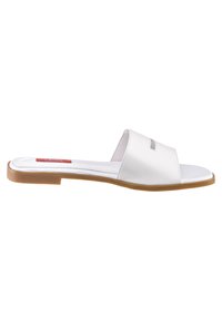 Sandale albe cu talpă plată din cauciuc maro, cu superior sintetic neted, cu vârf deschis. Prezintă un design cu decupaj pe curea.