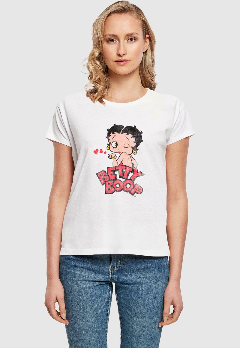 Valge T-särk, millel on värviline Betty Boopi graafika koos südamekujude ja punase tekstiga "BETTY BOOP", lõdva istuvuse disainiga.