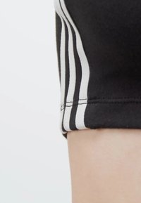 Zwarte sportshorts met witte verticale strepen aan de zijkanten, voorzien van een gestikte zoom. Glad, rekbaar materiaal met een figuurgetailleerde pasvorm.