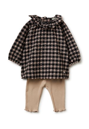 Haut pour tout-petit à manches longues, col à volants, à carreaux noirs et beiges, associé à des leggings beiges côtelés avec des bordures ondulées aux poignets.