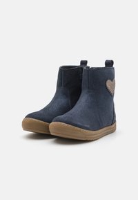 Botas de tornozeleira azul-marinho com um acabamento em camurça texturizada, sola de borracha e um detalhe de coração brilhante na lateral. Apresentam alças para fácil colocação.