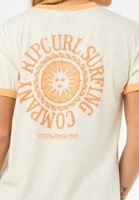 Crème t-shirt met oranje accenten, voorzien van een zonnenafbeelding en de tekst "RIPCURL SURFING COMPANY". Zacht, lichtgewicht katoen.