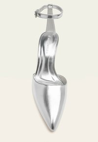 Stříbrná metalická střevíce na vysokém podpatku s špičatou špičkou, kotníkovým páskem a přezkou, velikost 37, vystavená z horního pohledu.