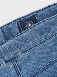 Denim pojas s tamnoplavim dugmetom i svjetloplavom tkaninom s glatkom teksturom i detaljima od šivanja.
