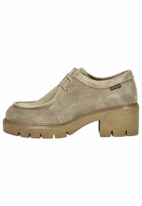 Beige ruskindsko med afrundet næse, syninger og en kraftig brun gummisål. Har snørebånd og et logomærke på siden.