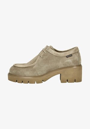 Chaussure en suédine beige avec un bout arrondi, des détails cousus et une semelle en caoutchouc marron épaisse. Comprend des lacets et une étiquette de logo sur le côté.