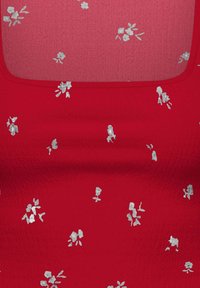 Tissu rouge avec de petits motifs floraux argentés répartis uniformément sur la surface, avec un bord d'encolure arrondi.