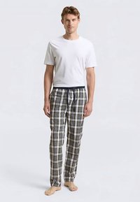 Herrpyjamas i set med en vit bomulls-T-shirt med rund hals och rutiga byxor i grönt, marinblått och vitt med dragsko i midjan.