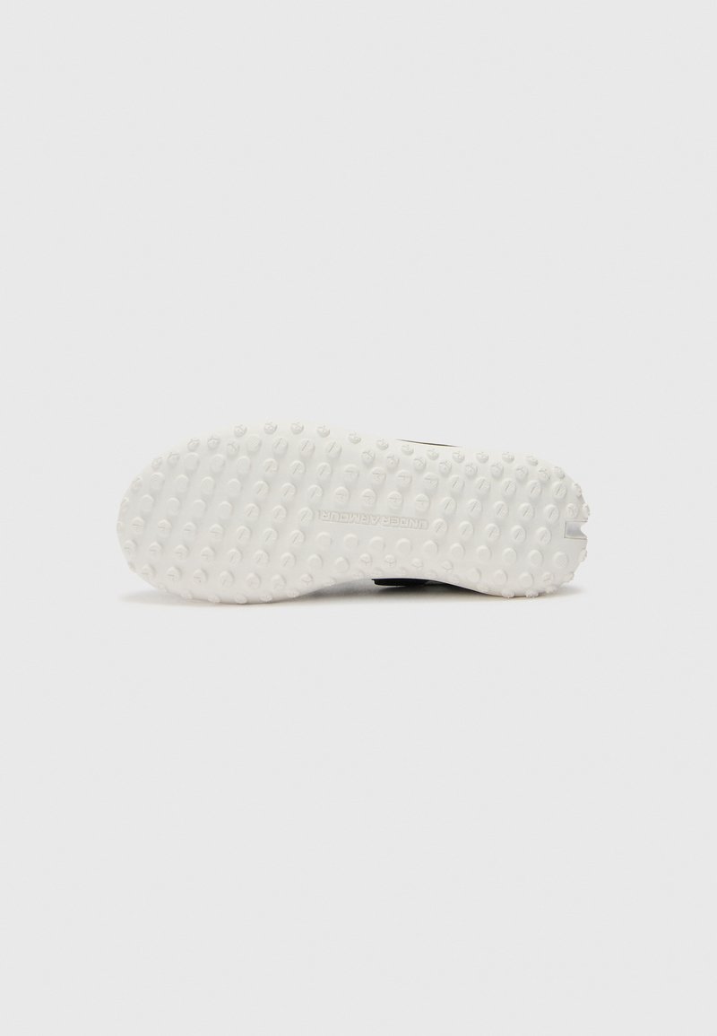 Suela de zapatilla negra con goma blanca, con una superficie texturizada que presenta pequeñas empuñaduras circulares y el nombre de la marca grabado "UNDER ARMOUR".