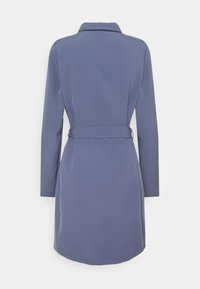 Šedý opásaný kabát s límcem, dlouhými rukávy a hladkým povrchem. Má přiléhavý siluetu a mírně rozšířený lem.