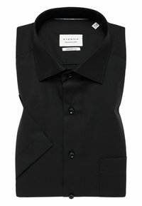 Maglietta nera a maniche lunghe realizzata in tessuto morbido, con colletto alla francese, cinque bottoni e una tasca sul petto.