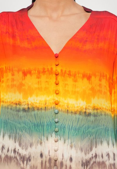 Mehrfarbige Bluse mit Farbverlauf, tiefem V-Ausschnitt und runden Knöpfen in Rot, Orange, Blau und Beige, mit einer glatten, seidigen Textur.