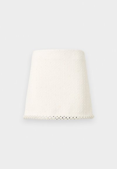 Mini-jupe blanche texturée à coupe droite, avec une bordure perlée le long de l'ourlet inférieur.