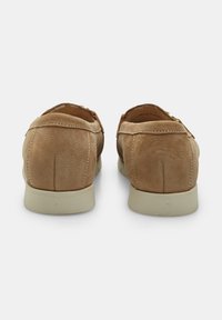 Hellbraune Lederloafer mit glatter Oberfläche, runder Form und cremefarbener, kontrastierender Sohle. Sichtbare Nähte entlang der Kanten.