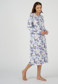 Camisa de noche floral de mangas largas, con una paleta de colores en azul claro y blanco, textura acanalada y un escote redondo con pequeños acentos azules.