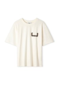 Crème-kleurig katoenen t-shirt met korte mouwen, voorzien van een getextureerde grafiek in een donkere tint op de linkerkant van de borst. Zachte, ontspannen pasvorm.