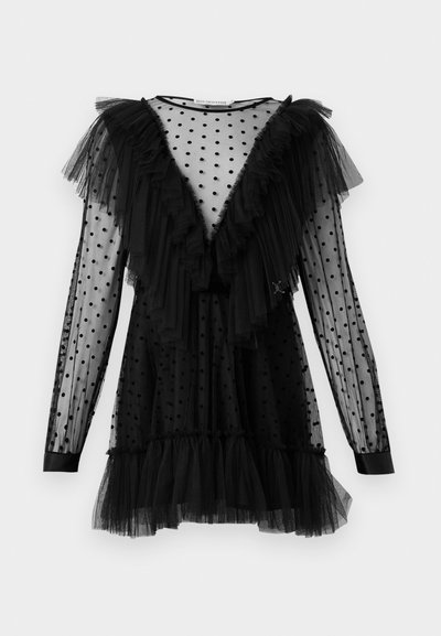 Robe en tulle noire à manches longues, couverte de pois noirs. Présente des accents volants le long de l'encolure et de l'ourlet, avec une silhouette ajustée.