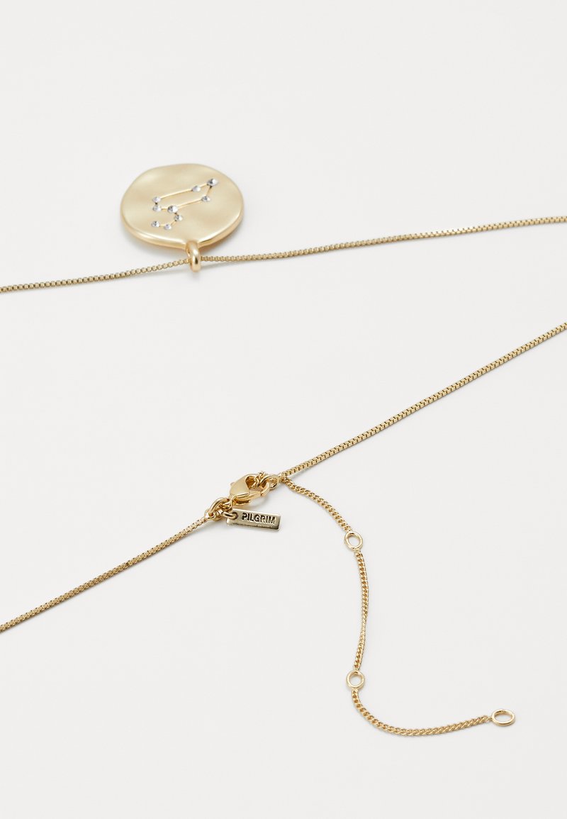 Collar de oro con colgante redondo que presenta un diseño de constelación estelar hecho de pequeños cristales, y un cierre con una etiqueta de la marca Pilgrim.
