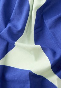 Tela de algodón con un audaz patrón geométrico en colores azul oscuro y verde claro, con una textura suave y tersa y bloques de color definidos.