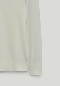 Maglione a maglia color crema con polsini a costine, caratterizzato da una texture morbida e da un design semplice e lineare. Nessun motivo visibile o elementi metallici.