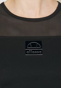 Černé sportovní tričko s texturovaným, prodyšným designem a logem ve středu. Má kulatý výstřih a přiléhavý střih.