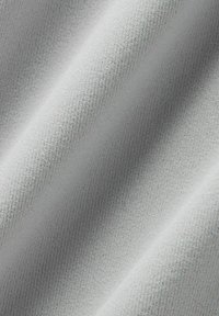 Világosszürke, texturált anyag, lágy bordázott felülettel; sima és enyhén fényvisszaverő felület, amely finom redőket és árnyékokat hoz létre.