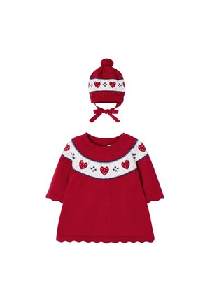 Rød babykjole med lange ærmer og hvid bærestykke med røde hjerter og snefnug, kombineret med matchende rød strikket hue med kvast og bindebånd.